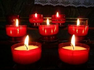 Yellow candles in red jars lit